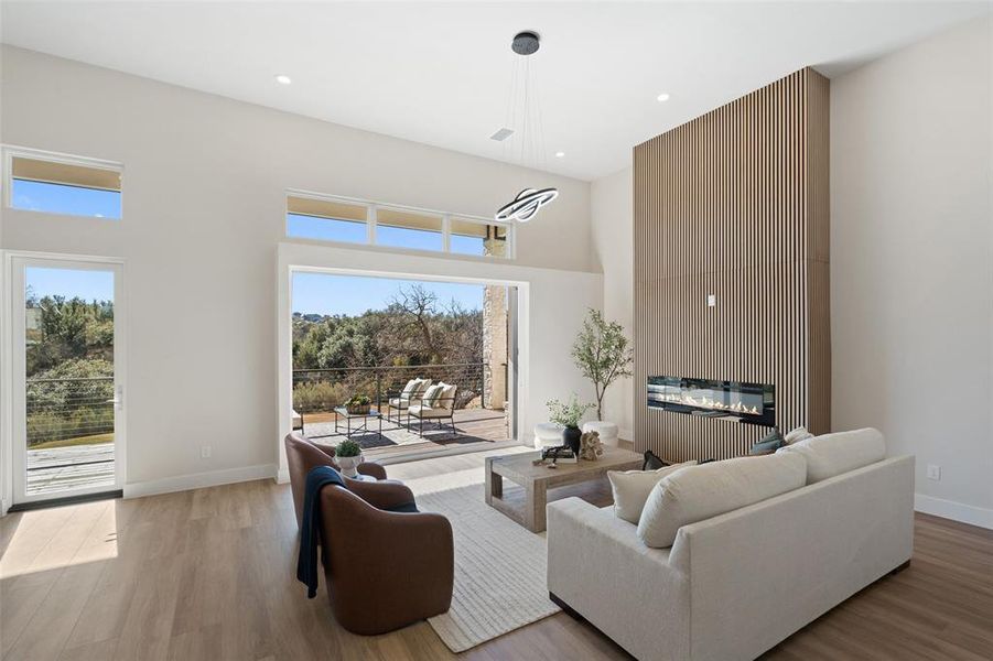 Living room featuring a towering ceiling, light wood-style floors, and recessed lighting Living room featuring a towering ceiling, light wood-style floors, and recessed lighting