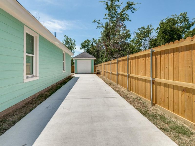 View of yard featuring a garage and an outbuilding