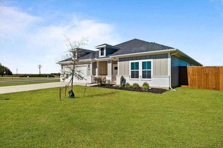 View of front facade featuring a front yard and a garage