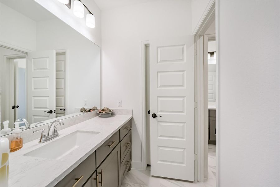 Upstairs bathroom featuring a sleek quartz countertop paired with a modern undermount sink. Upstairs bathroom featuring a sleek quartz countertop paired with a modern undermount sink.