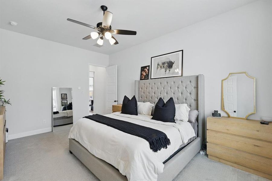 Bedroom featuring baseboards, light colored carpet, and a ceiling fan