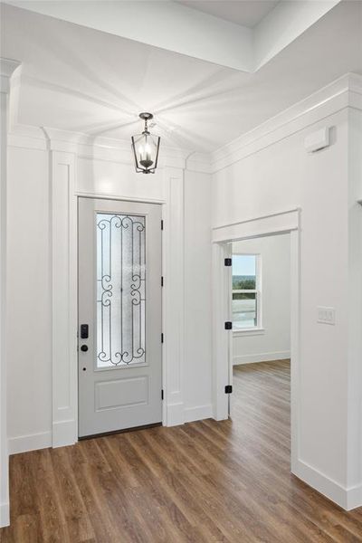 Entryway featuring an inviting chandelier and dark hardwood / wood-style floors