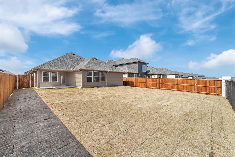 Back of property with a patio area, a fenced backyard, and roof with shingles Back of property with a patio area, a fenced backyard, and roof with shingles