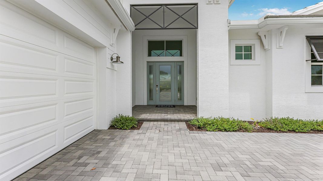 Front exterior of a new home in L'Ambiance at Avenir, Palm Beach Gardens, FL, highlighting curb appeal (Image 1).