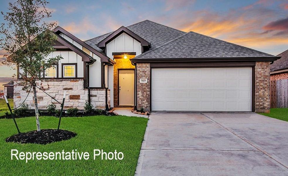 View of front of property with a garage and a yard