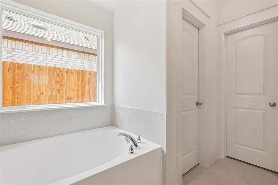 Bathroom featuring a bath and tile patterned floors