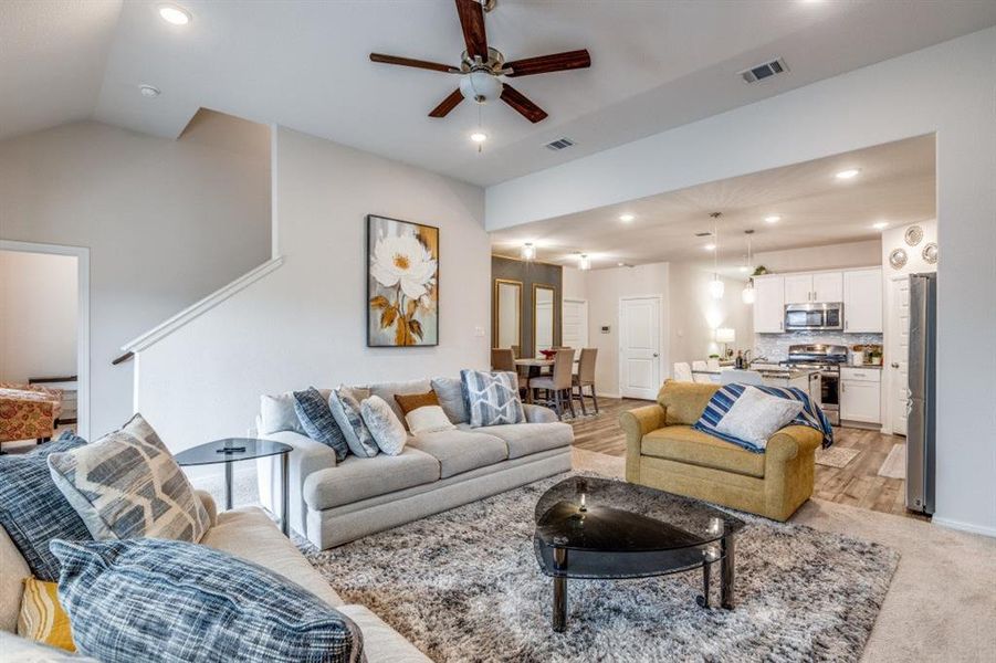 Living area featuring recessed lighting, ceiling fan, light wood-style floors, and stairs
