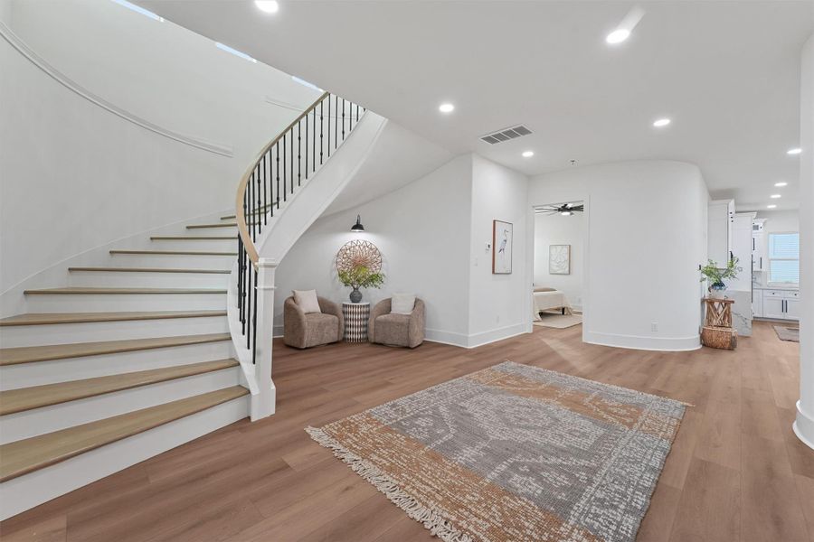 The elegant spiral staircase makes a bold first impression in the grand entryway, complete with a cozy reading nook tucked below. The elegant spiral staircase makes a bold first impression in the grand entryway, complete with a cozy reading nook tucked below.