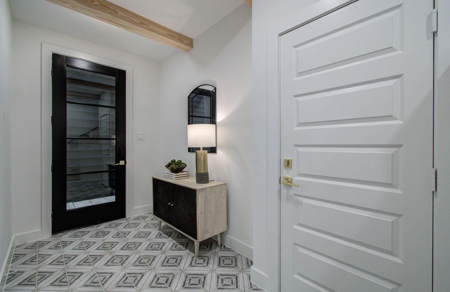 Steel and glass door makes a statement and sets the stage for this modern home. Beautiful pattern tile adds a unique touch.