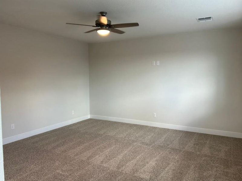 Empty room with carpet floors and ceiling fan