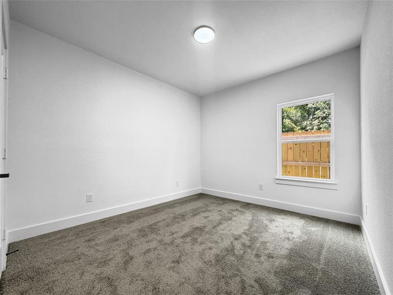 Empty room featuring carpet and baseboards