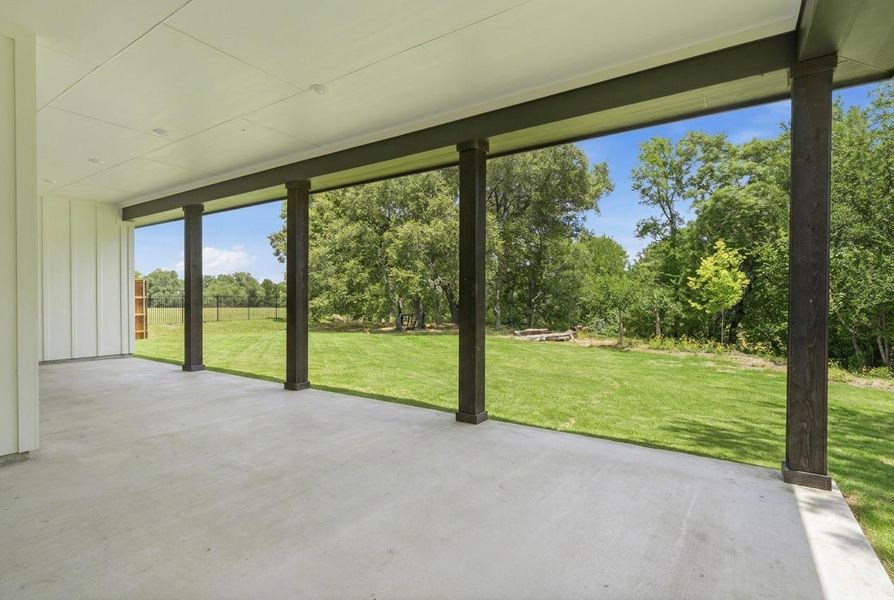 A spacious covered patio overlooks a generous, verdant lawn, ideal for outdoor leisure. A spacious covered patio overlooks a generous, verdant lawn, ideal for outdoor leisure.