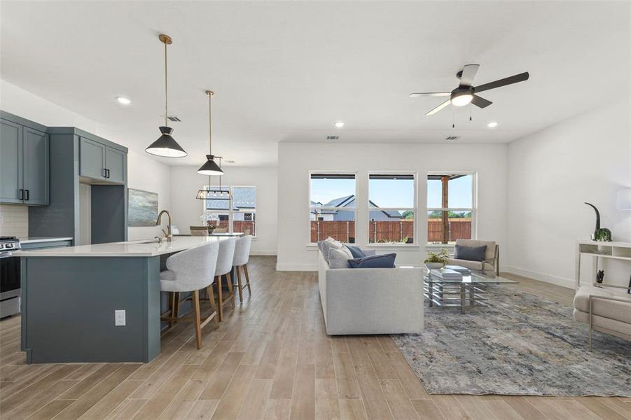 Living room with sink, ceiling fan, and light hardwood / wood-style flooring