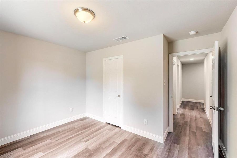 Unfurnished bedroom with light wood-type flooring and a closet