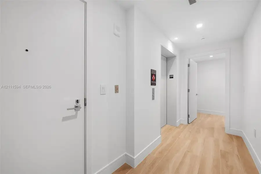 Interior hallway featuring wood-finish flooring, recessed lighting, and a dedicated elevator entrance Interior hallway featuring wood-finish flooring, recessed lighting, and a dedicated elevator entrance
