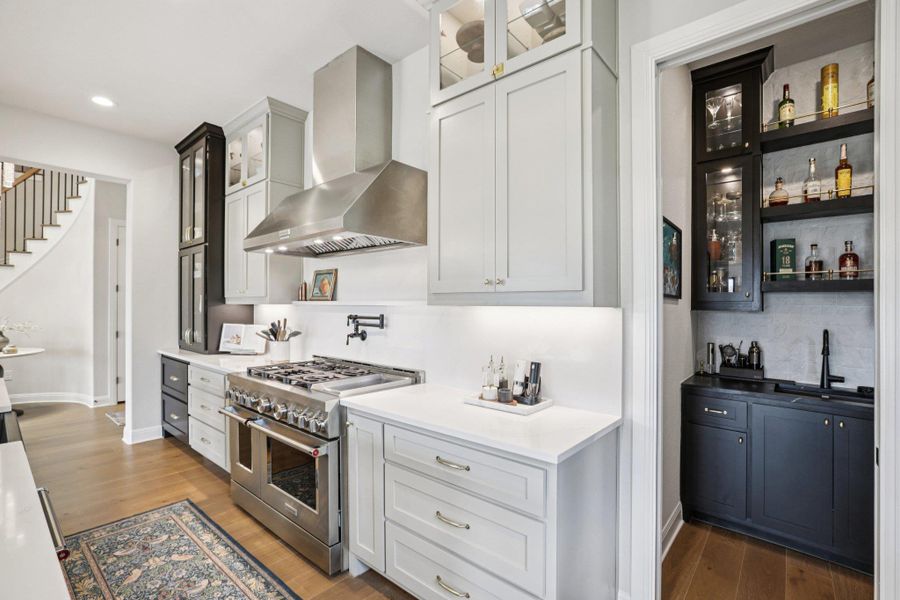 Behind the scenes, a hidden prep pantry equipped with a built-in wet bar keeps the main kitchen clutter-free.