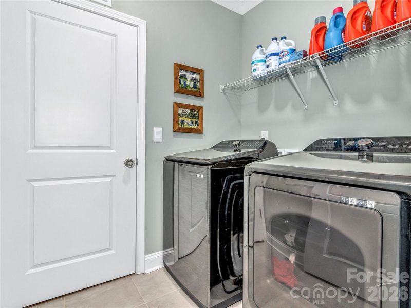 Laundry room that opens to both the primary walkin closet and the hallway to other bedrooms.