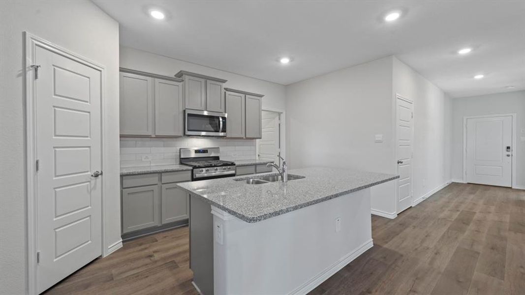 Kitchen featuring gray cabinets, light stone countertops, tasteful backsplash, stainless steel appliances, and recessed lighting Kitchen featuring gray cabinets, light stone countertops, tasteful backsplash, stainless steel appliances, and recessed lighting