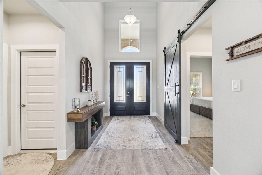 Stunning front entry with dramatic height, decorative lighting, and custom touches like the dark stain double doors and sliding barn door. Stunning front entry with dramatic height, decorative lighting, and custom touches like the dark stain double doors and sliding barn door.