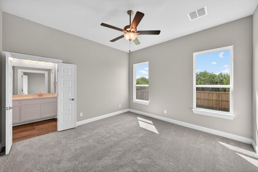 Unfurnished bedroom featuring light carpet, a ceiling fan, and ensuite bathroom Unfurnished bedroom featuring light carpet, a ceiling fan, and ensuite bathroom