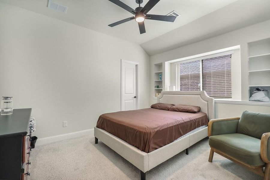 Bedroom with light carpet, a ceiling fan, and lofted ceiling Bedroom with light carpet, a ceiling fan, and lofted ceiling