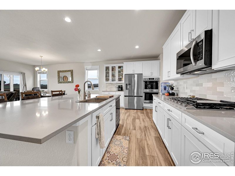 Kitchen with upgraded cabinet, quartz counters, new backsplash, gas range and stainless steel appliances