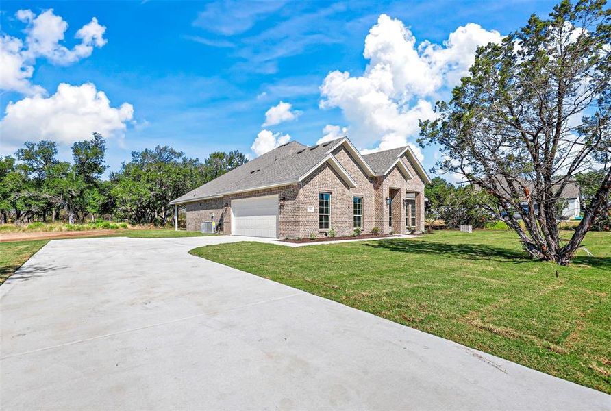 View of front of home with a garage and a front lawn