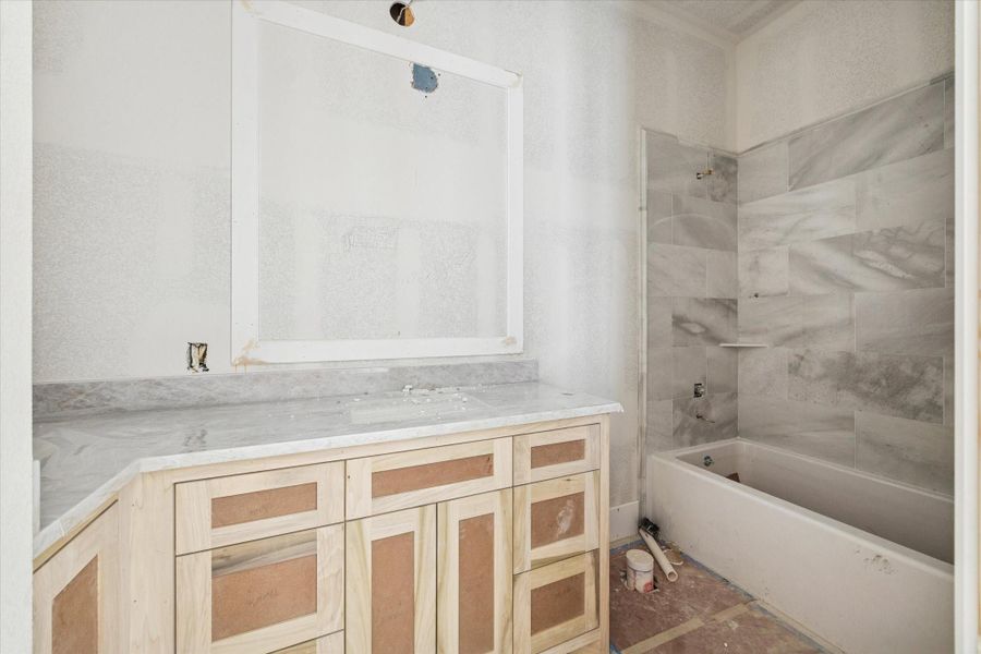 Spacious secondary bathroom with oversized vanity and tile tub surround. Spacious secondary bathroom with oversized vanity and tile tub surround.