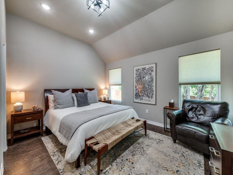 Bedroom featuring multiple windows, wood finished floors, baseboards, recessed lighting, and vaulted ceiling Bedroom featuring multiple windows, wood finished floors, baseboards, recessed lighting, and vaulted ceiling