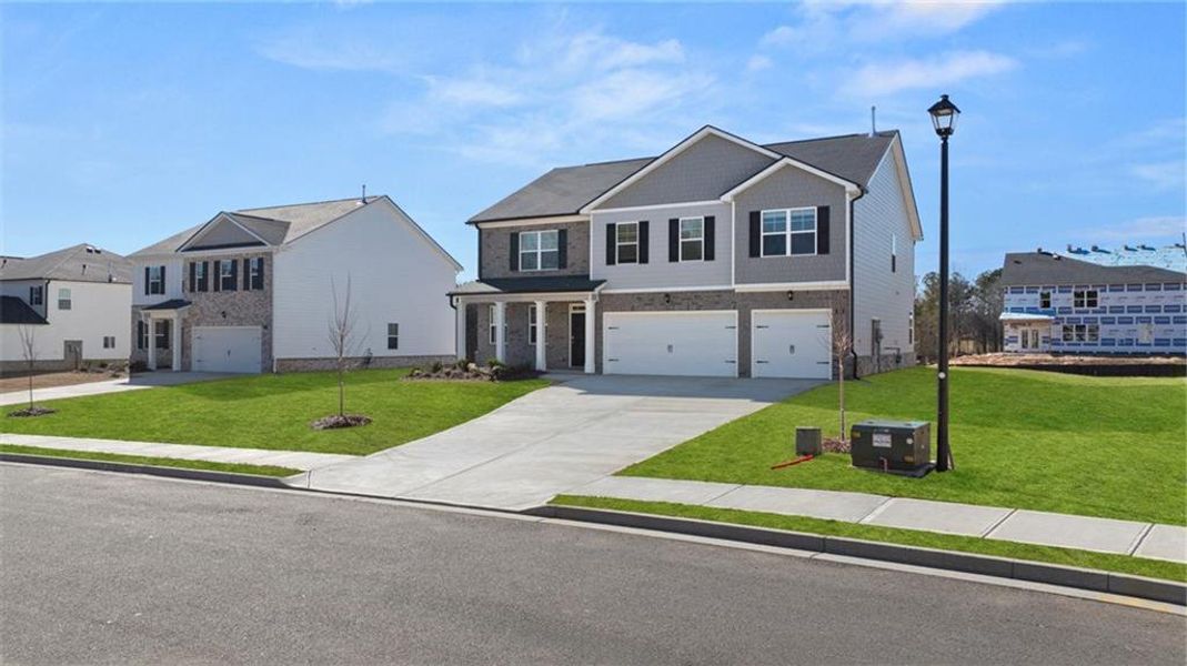 Front exterior of a new home in Bridle Creek, Locust Grove, GA, highlighting curb appeal (Image 1).