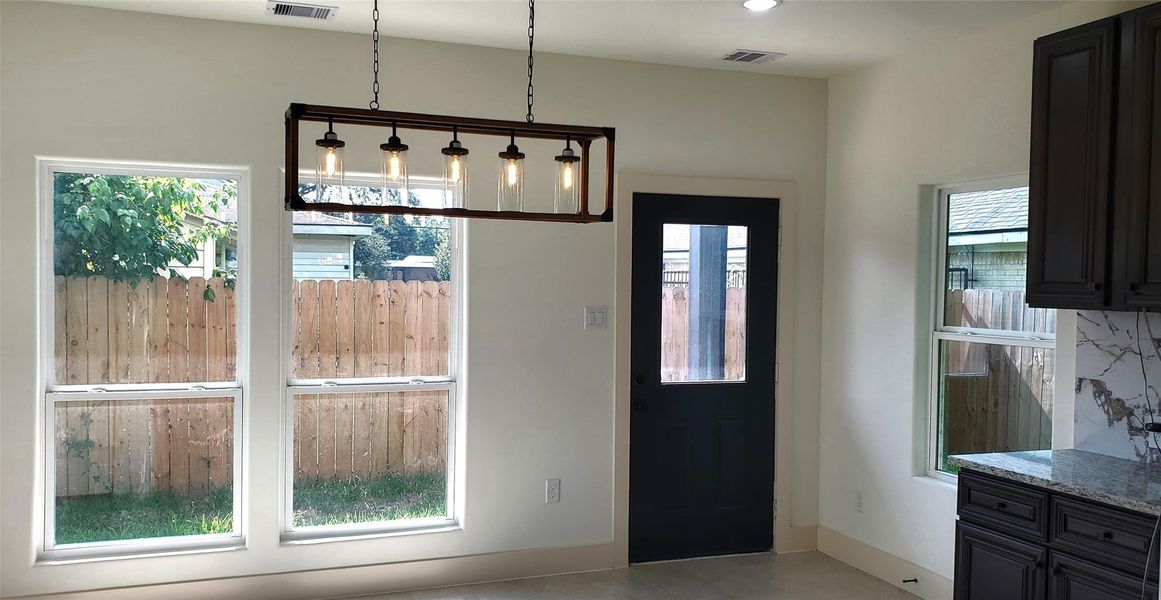 Dining area features lots of natural lighting and view of side patio.