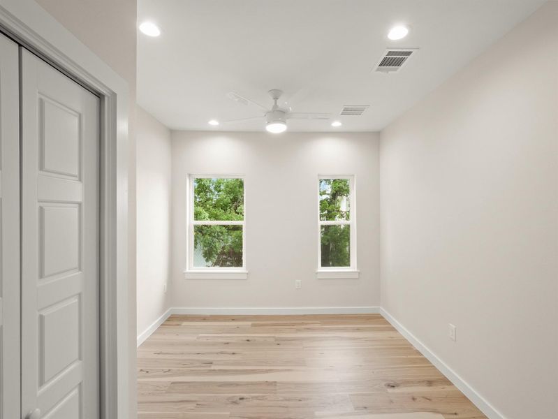 Room featuring light wood-finish flooring, white walls, and a ceiling fan