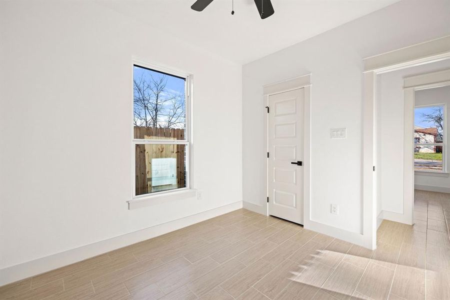 Unfurnished bedroom with ceiling fan, light wood-type flooring, and baseboards