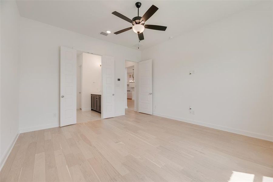 Unfurnished bedroom featuring light wood-type flooring, ceiling fan, and ensuite bathroom Unfurnished bedroom featuring light wood-type flooring, ceiling fan, and ensuite bathroom