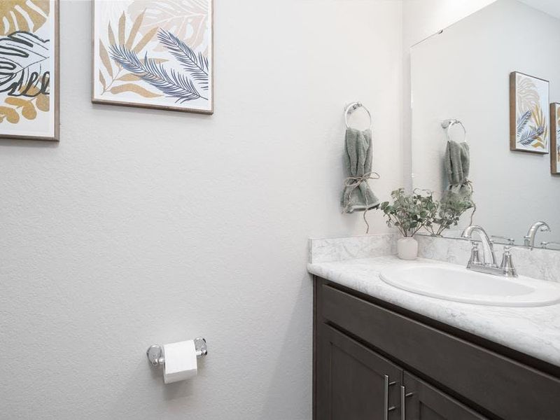 A convenient downstairs powder room serves guests - Magnolia townhome by Highland Homes A convenient downstairs powder room serves guests - Magnolia townhome by Highland Homes