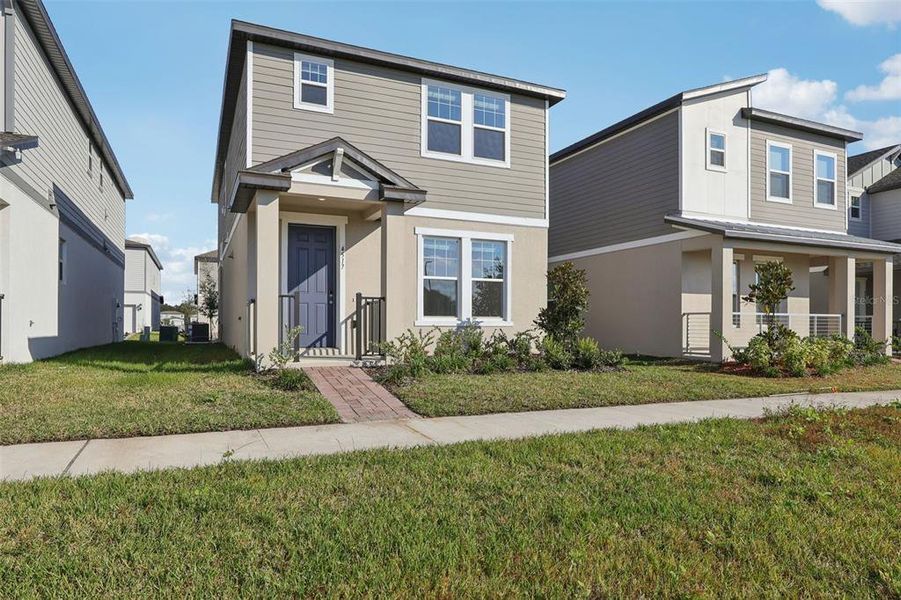 Front exterior of a new home in The Meadow at Crossprairie Bungalows, St. Cloud, FL, highlighting curb appeal (Image 24).