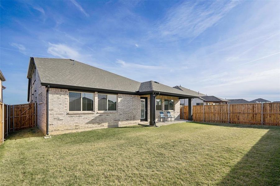 Back of house with a lawn and a patio area