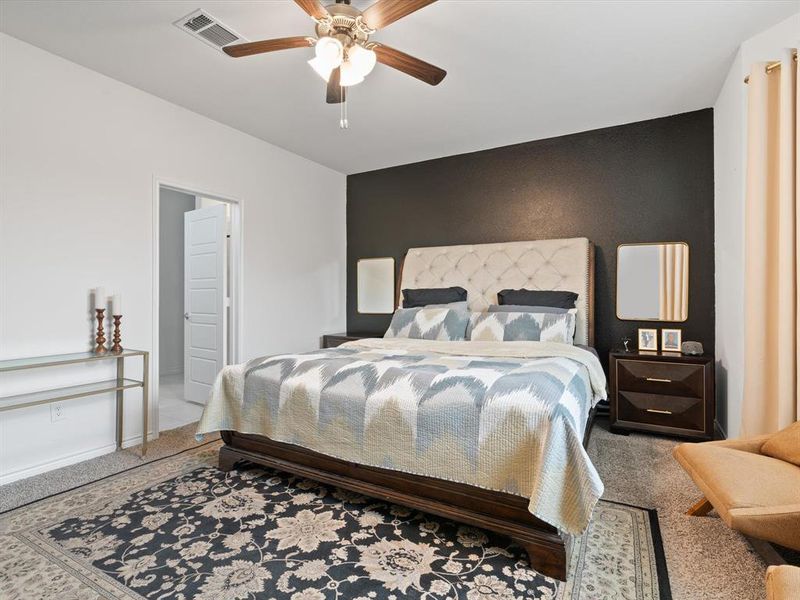 Carpeted bedroom featuring ceiling fan