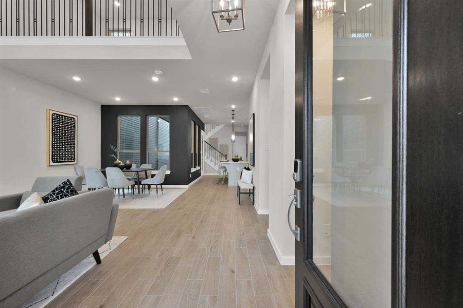 Contemporary glass-paneled front door welcomes you inside with natural light. (Original Builder Staged Photo 2024)