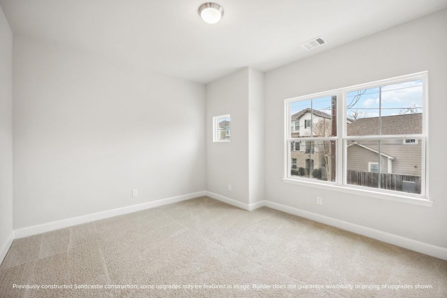 Light and spacious, this larger secondary bedroom at the front of the house shines.