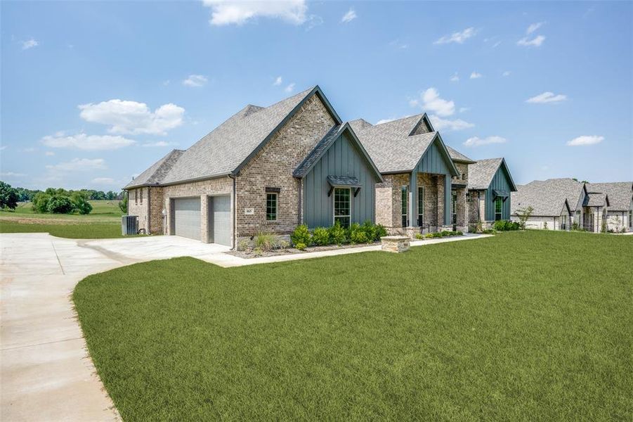 View of front of property featuring a garage and a front yard