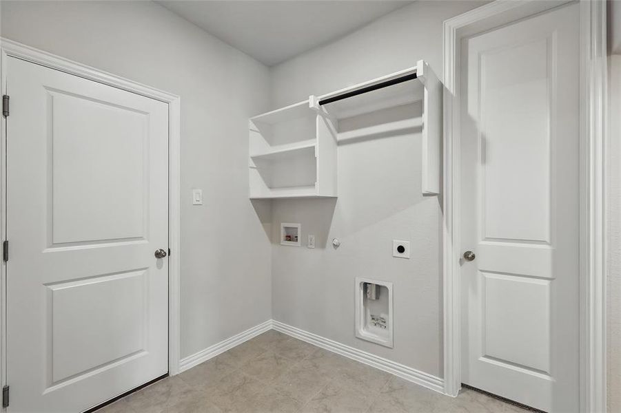 Laundry area featuring hookup for a gas dryer, hookup for an electric dryer, washer hookup, and baseboards Laundry area featuring hookup for a gas dryer, hookup for an electric dryer, washer hookup, and baseboards