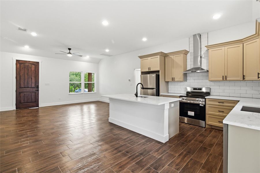 A contemporary open-concept space features warm wood flooring, a central island kitchen, and generous natural light. A contemporary open-concept space features warm wood flooring, a central island kitchen, and generous natural light.