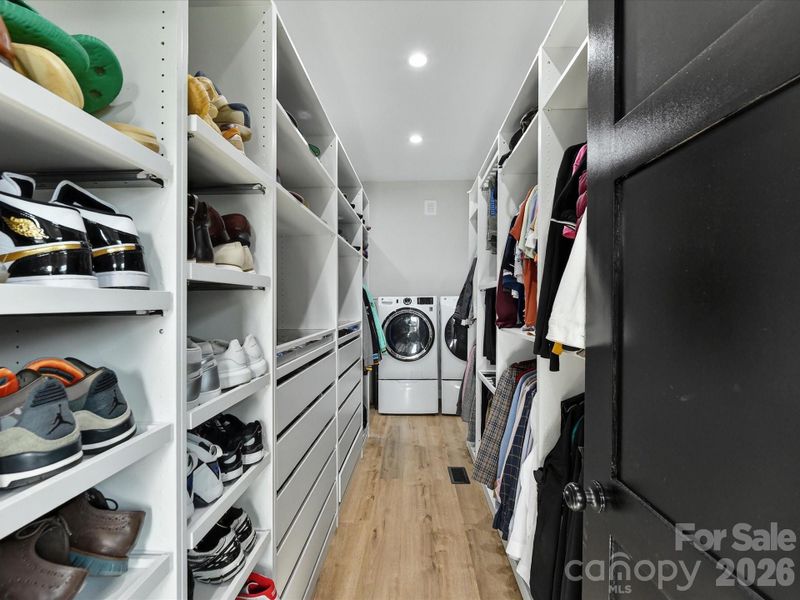 Spacious primary suite closet with custom built-ins, abundant storage, and a convenient in-closet laundry area.