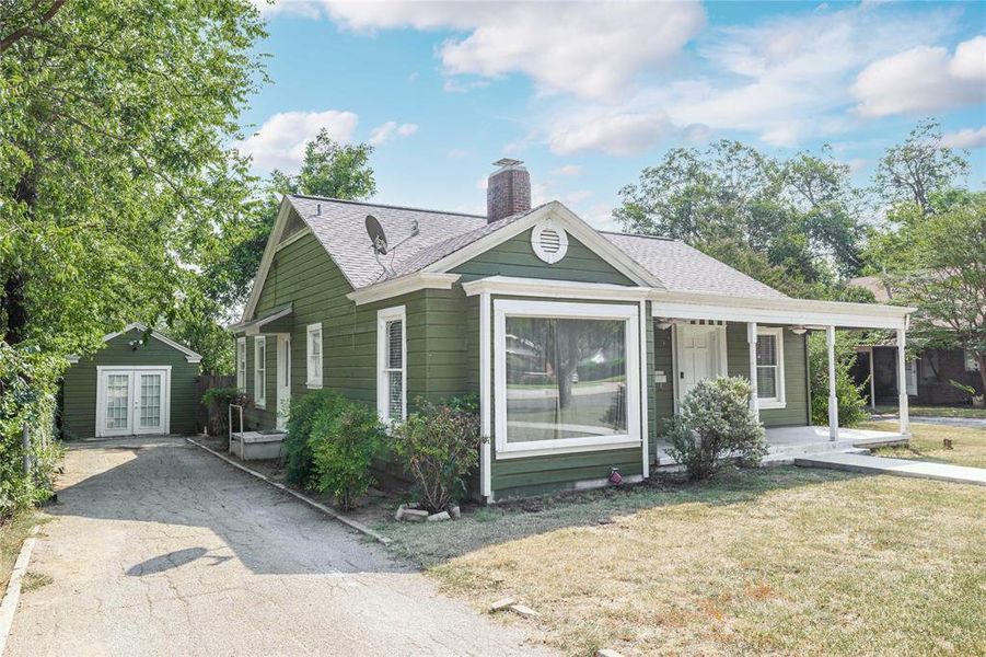 Bungalow with a porch, roof with shingles, a chimney, and a front yard Bungalow with a porch, roof with shingles, a chimney, and a front yard