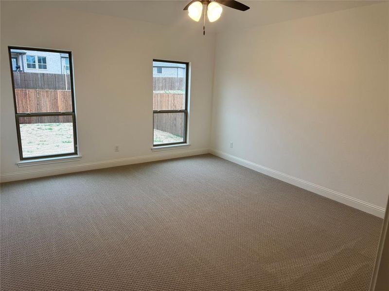 Empty room featuring ceiling fan and carpet flooring