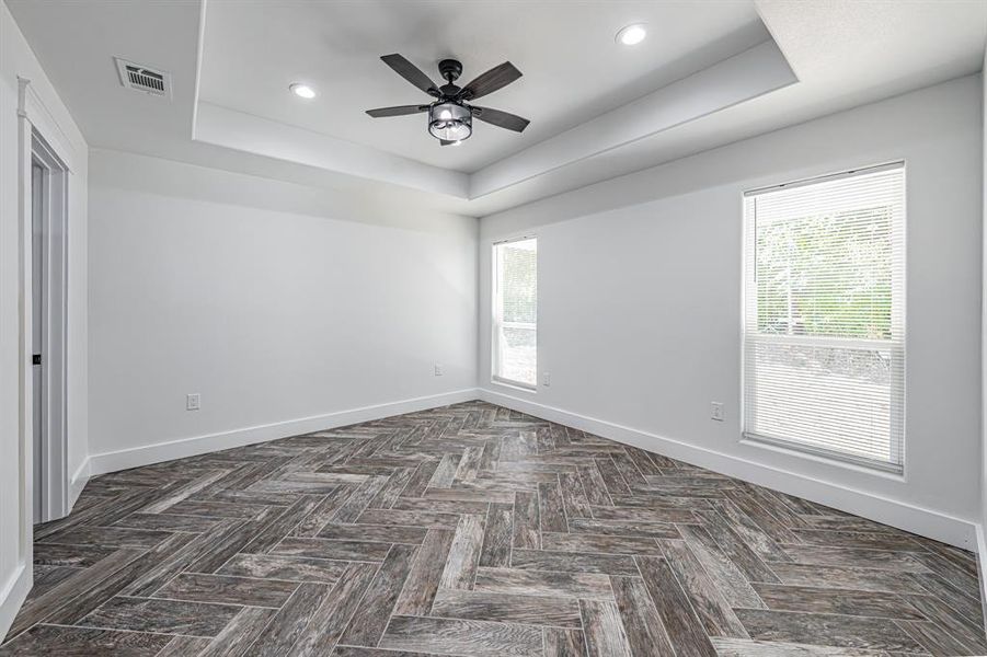 Spare room featuring a tray ceiling, recessed lighting, and a ceiling fan Spare room featuring a tray ceiling, recessed lighting, and a ceiling fan