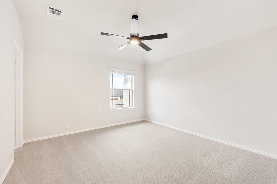 Empty bedroom with light carpet, white walls, ceiling fan, and single window