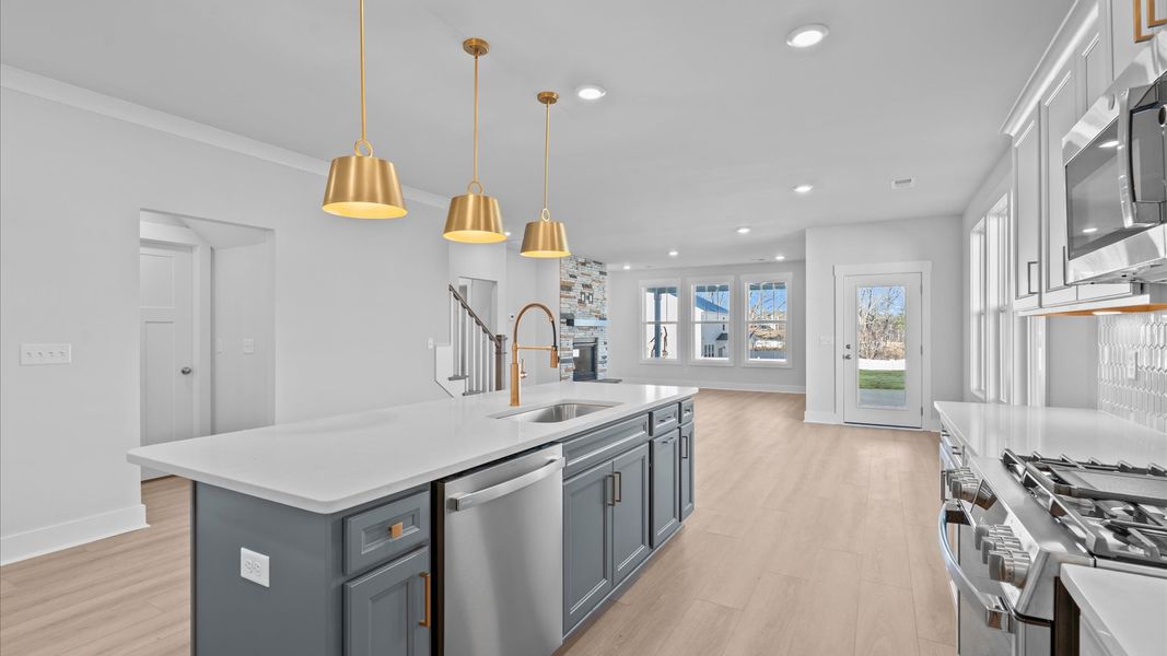 Superior kitchen with quartz countertops, pendant lighting, and a generously sized island