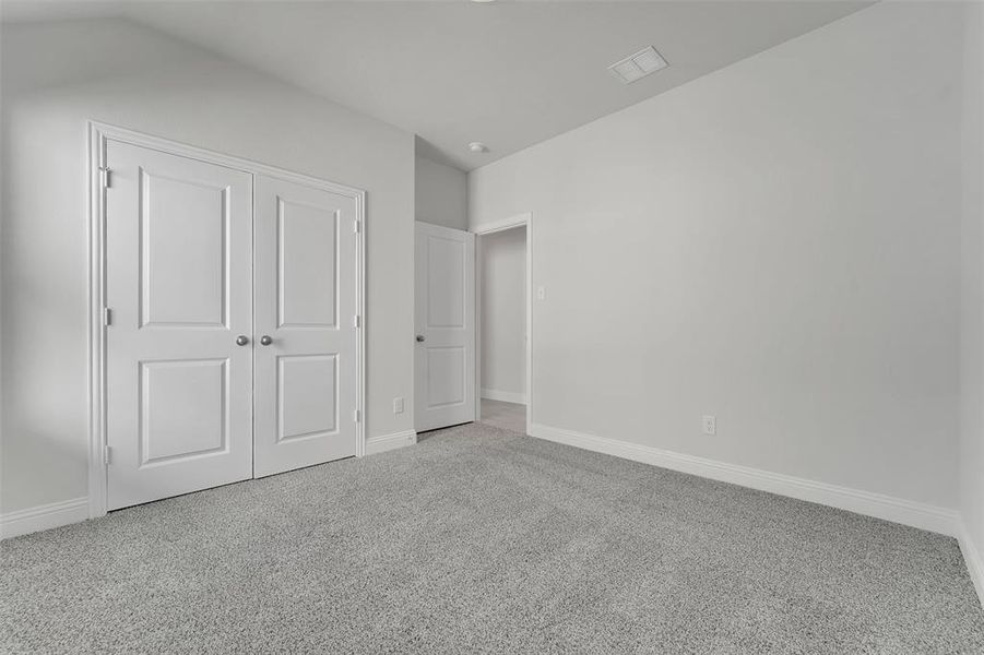 Unfurnished bedroom with a closet, carpet flooring, visible vents, and baseboards Unfurnished bedroom with a closet, carpet flooring, visible vents, and baseboards